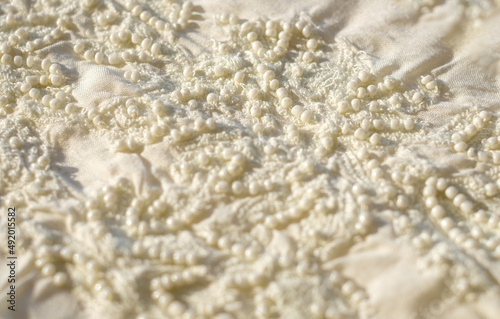 White lace textile fabric with beads close-up, wedding abstract background