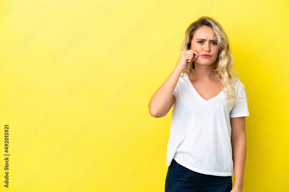 Young Brazilian woman isolated on yellow background showing a sign of silence gesture Young Brazilian woman isolated on yellow background showing a sign of silence gesture