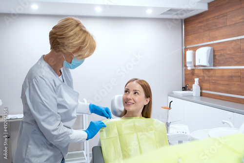 Stomatologist preparing patient to teeth treatment procedure