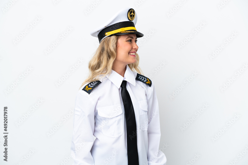 Airplane Brazilian pilot isolated on white background looking to the side and smiling