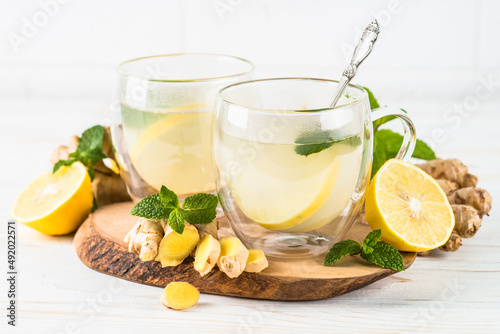 Ginger tea with lemon and mint in glass mug. Healthy hot vitamin drink.