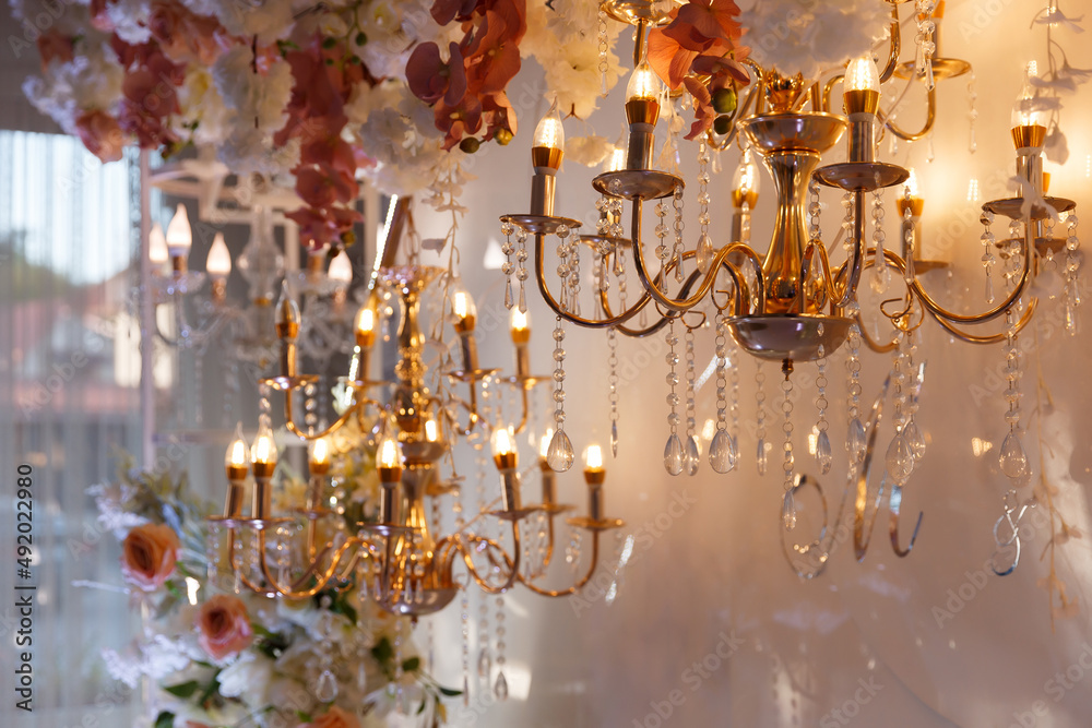 vintage gilded chandeliers scarcely glowing with warm light