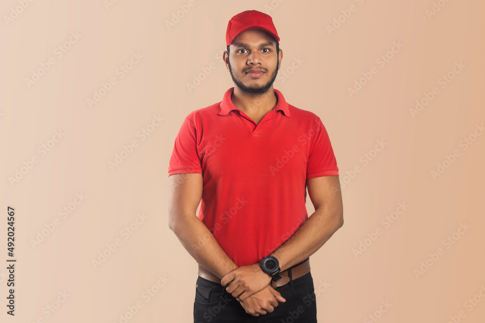 Confident young delivery man standing isolated on Color Background Confident young delivery man standing isolated on Color Background