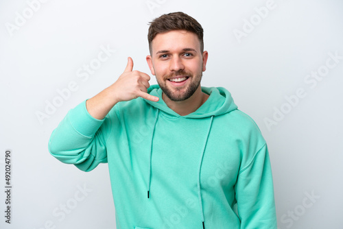 Young caucasian man isolated on white background making phone gesture. Call me back sign © luismolinero
