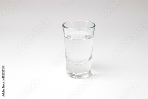 Shot with transparent liquid alcohol on a white background