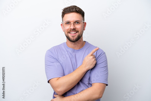 Young caucasian man isolated on white background pointing to the side to present a product