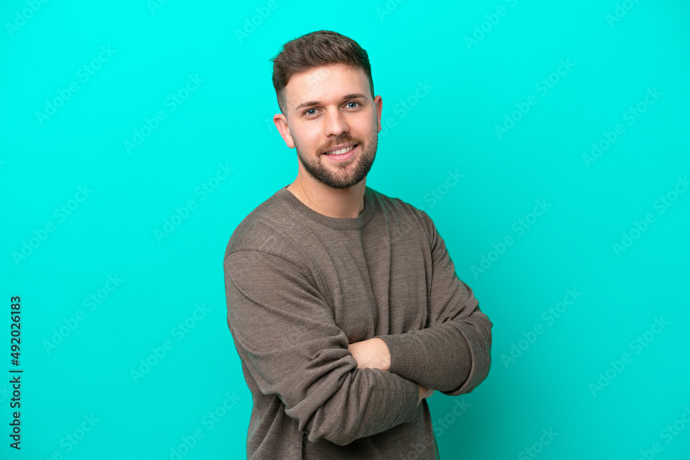 Young caucasian man isolated on blue background with arms crossed and looking forward Young caucasian man isolated on blue background with arms crossed and looking forward