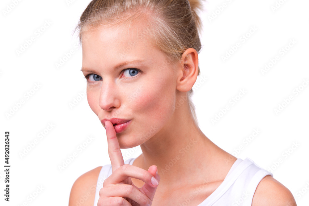 Keep it secret. Portrait of a beautiful young woman with her finger to her lips isolated on white.