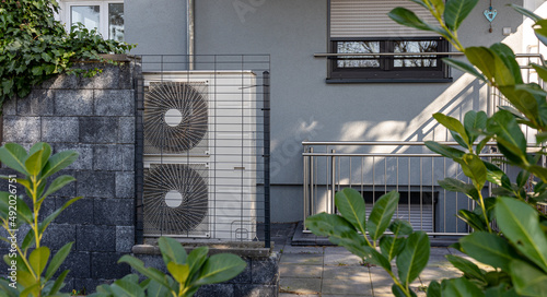 Fotografie, Obraz Air source heat pumps installed on the garden front  of a modern house