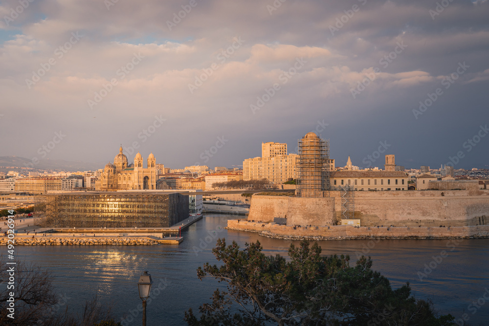 Sunset and night view over Cathedral, Fort and Mucem buildings in Marseille harbour, France