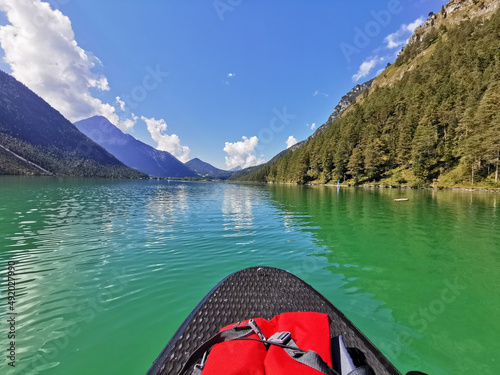 Surfing on the mountain lake with green-blue water in Tyrol, Alps.  © STV