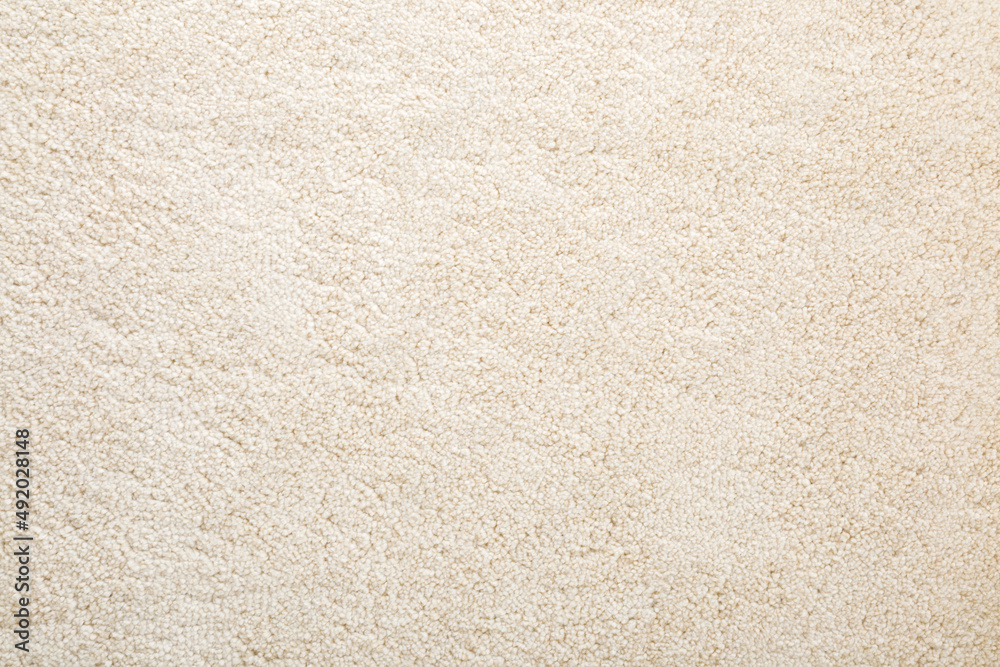Beige new fluffy home carpet background. Closeup. Empty place for text. Top down view. - obrazy, fototapety, plakaty 