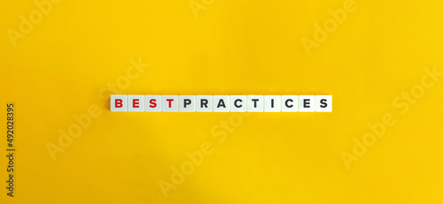 Best Practices Phrase on Block Letter Tiles on Yellow Orange Background. Minimal Aesthetics. photo