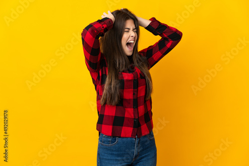 Teenager Brazilian girl isolated on yellow background stressed overwhelmed © luismolinero