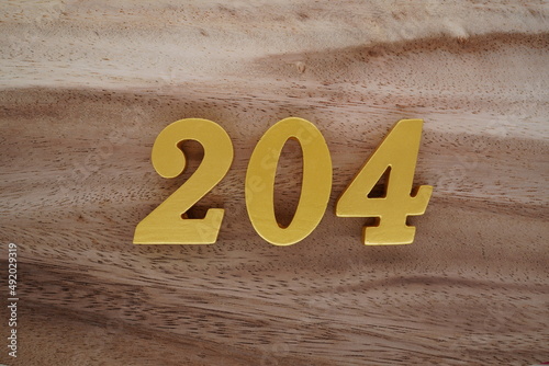 Golden Arabic numerals on a real brown and white wooden floor number 204