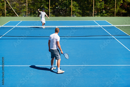 The game is on. People playing tennis on a tennis court. © Marine G/peopleimages.com