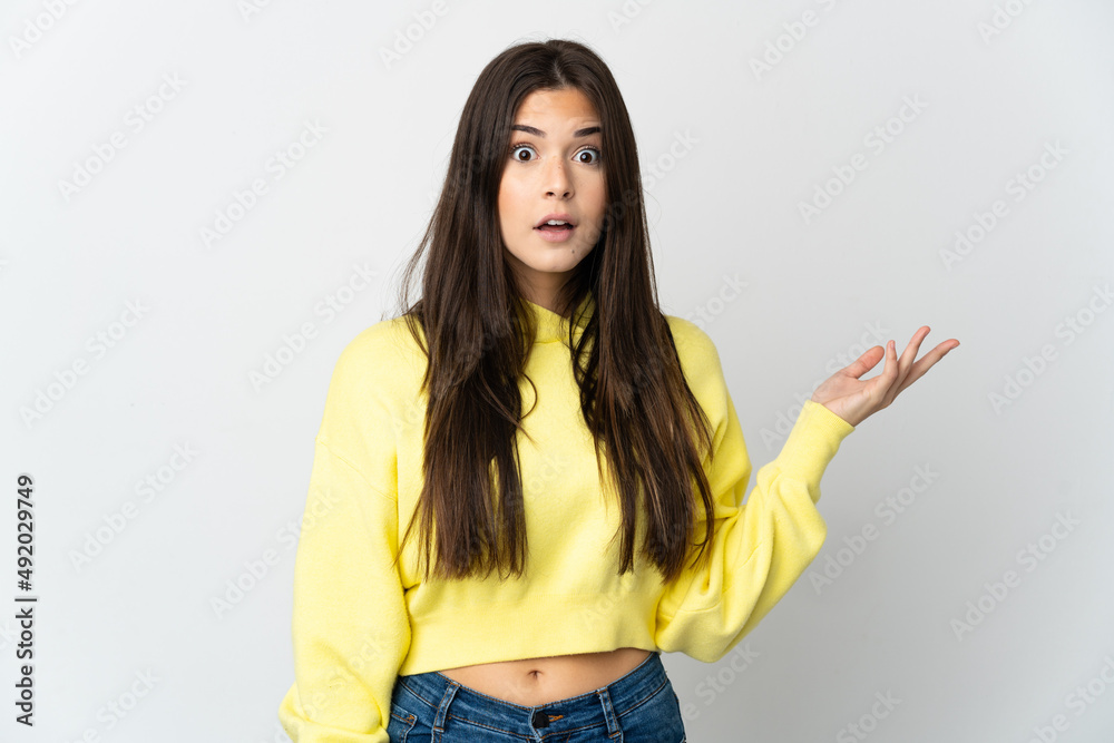 Teenager Brazilian girl isolated on white background making doubts gesture Teenager Brazilian girl isolated on white background making doubts gesture