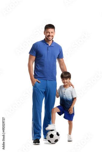 Little boy with soccer ball and trainer on white background