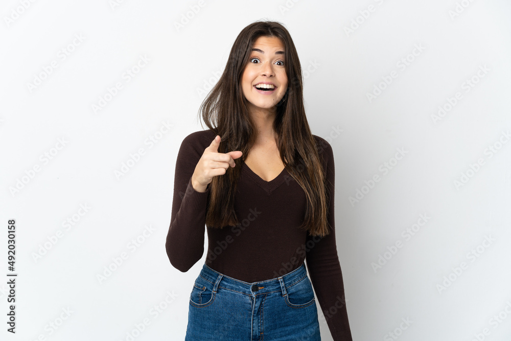 Teenager Brazilian girl isolated on white background surprised and pointing front Teenager Brazilian girl isolated on white background surprised and pointing front