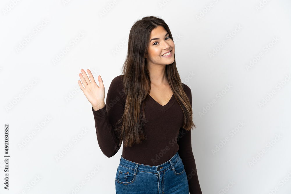 Teenager Brazilian girl isolated on white background saluting with hand with happy expression Teenager Brazilian girl isolated on white background saluting with hand with happy expression