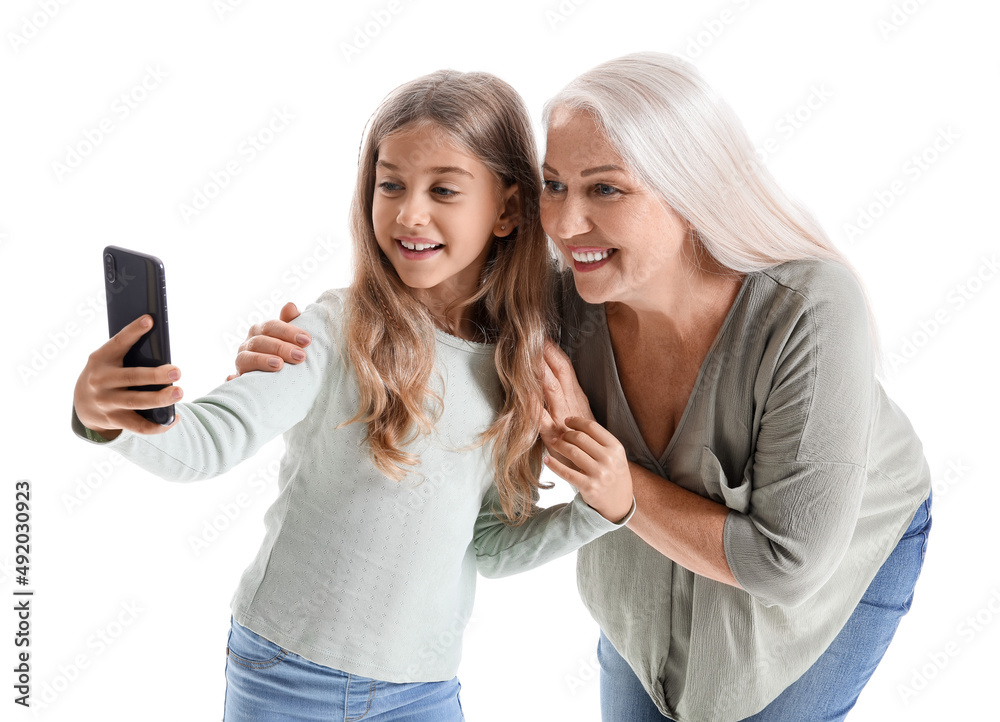 Little girl with her grandmother taking selfie on white background Little girl with her grandmother taking selfie on white background