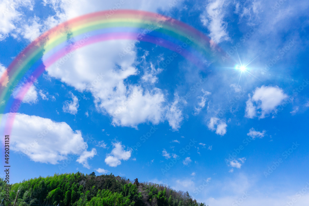 Bright blue sky with rainbow and sunshine_wide_26