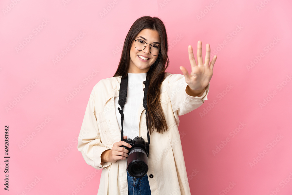 Young photographer Brazilian girl isolated on pink background counting five with fingers Young photographer Brazilian girl isolated on pink background counting five with fingers