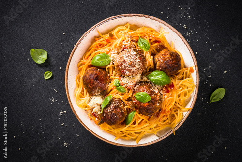 Pasta with Meatballs in tomato sauce on dark stone table. Traditional italian dish. Top view.