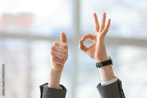 Businessman showing thumb-up and OK in office © Pixel-Shot