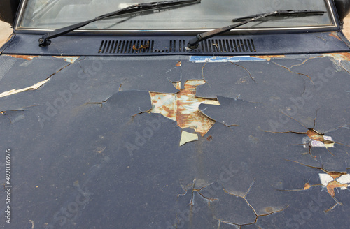 Old car paint broke off,cause is rusted steel surface of car