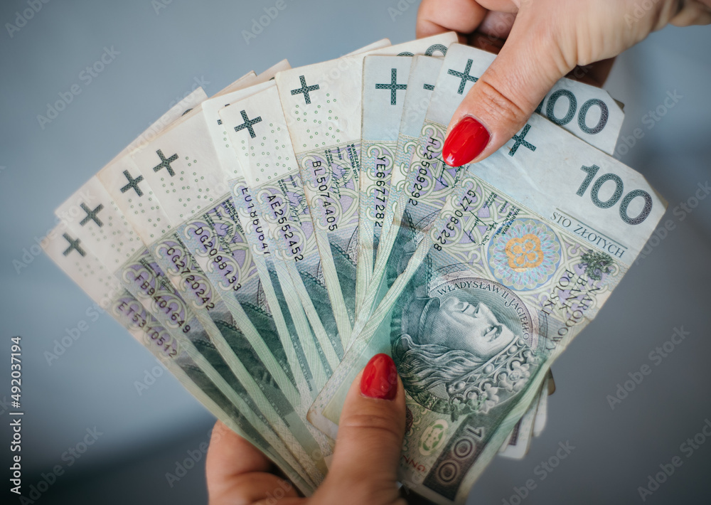Pieniądze polskie przeliczane w dłoniach. Banknoty stu złotowe - obrazy, fototapety, plakaty 