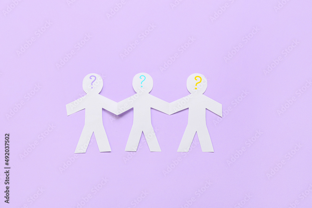 Paper human figures with question marks on lilac background. Concept of autistic disorder Paper human figures with question marks on lilac background. Concept of autistic disorder