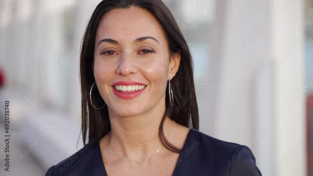 Smiling Hispanic woman in formal wear on street Smiling Hispanic woman in formal wear on street