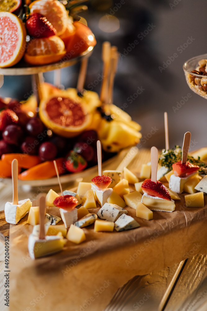 cheese platter served with nuts and berries, a gourmet cheese decorated with nuts and berries on a round Board, rich in flavor and combination