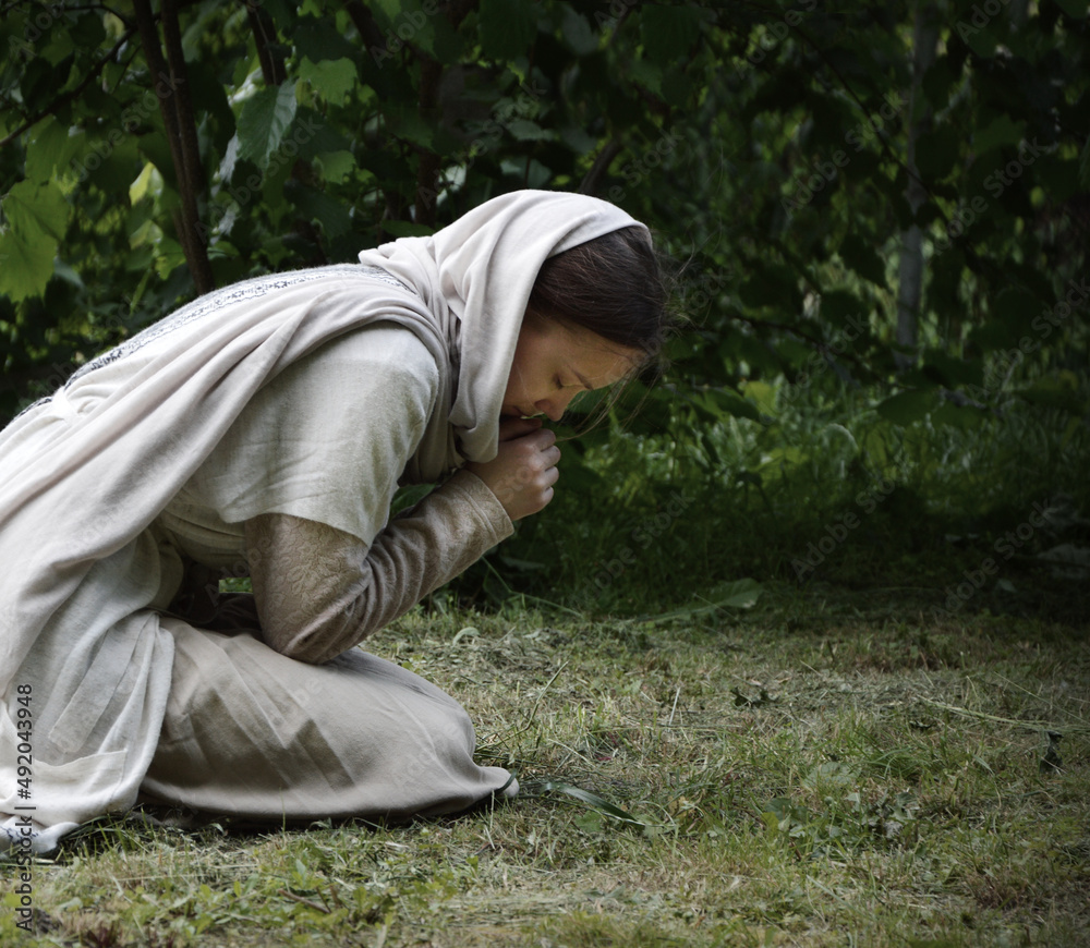 Praying woman on grass lawn Praying woman on grass lawn