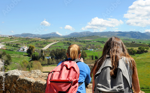 Two young girls with backpack traveling in Spain. View of the Sierra de Ronda from the city walls. Tourism in Ronda Andalusia Spain