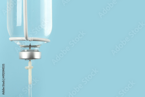IV infusion set on light blue background, closeup. Space for text