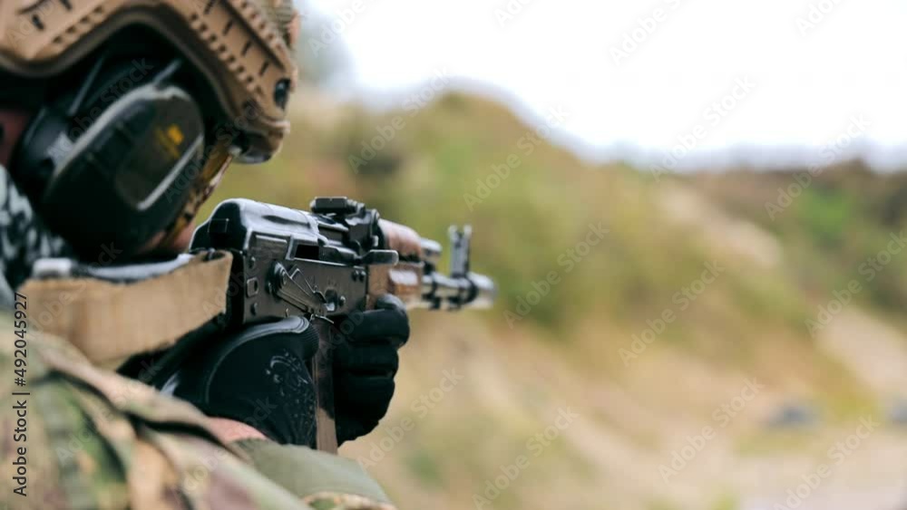 A military soldier aims and fires a machine gun. Military actions on the territory of Ukraine. Russia's war against Ukraine A military soldier aims and fires a machine gun. Military actions on the territory of Ukraine. Russia's war against Ukraine