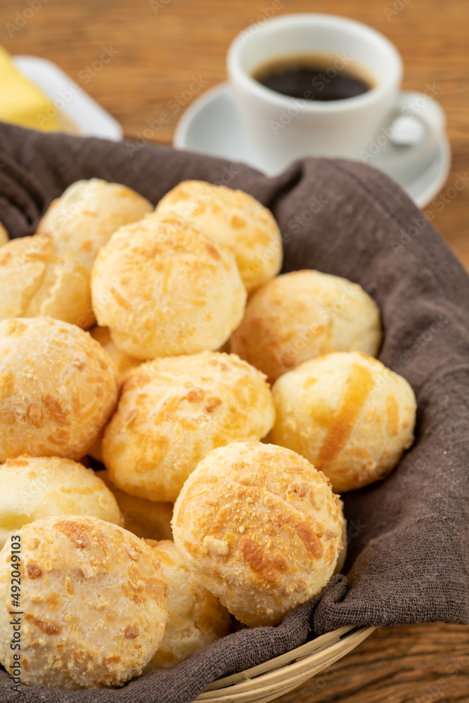 Typical brazilian cheese bun in a basket, coffee and butter Typical brazilian cheese bun in a basket, coffee and butter