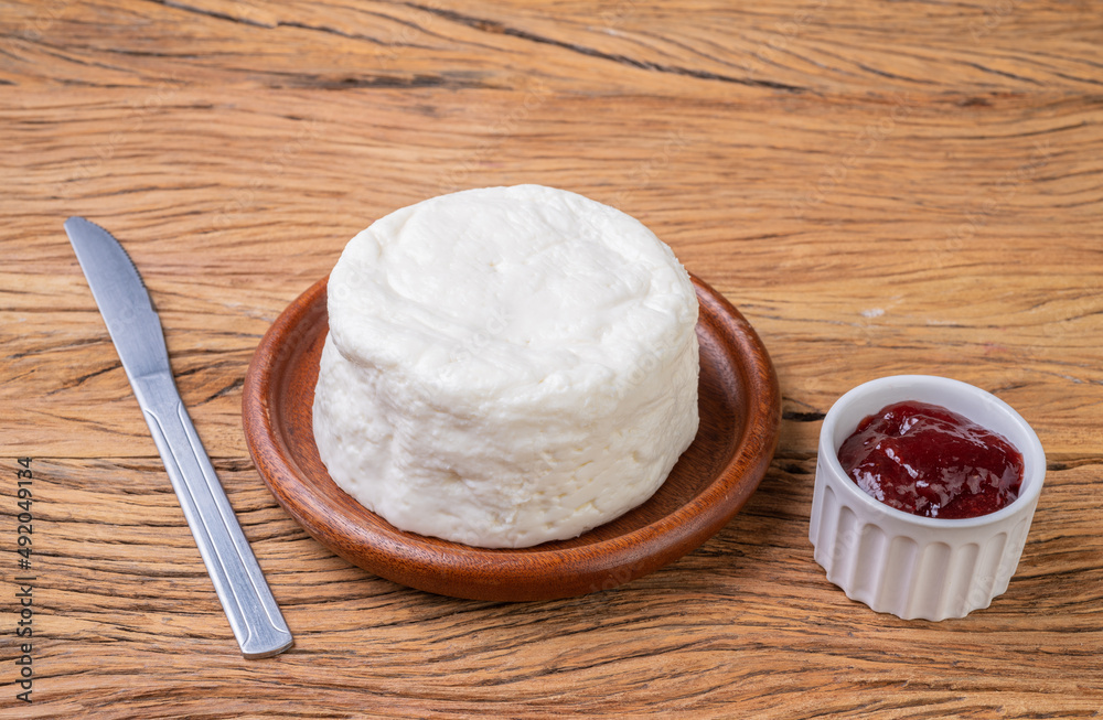 Frescal cheese, typical brazilian fresh white cheese with strawberry jam over wooden table Frescal cheese, typical brazilian fresh white cheese with strawberry jam over wooden table