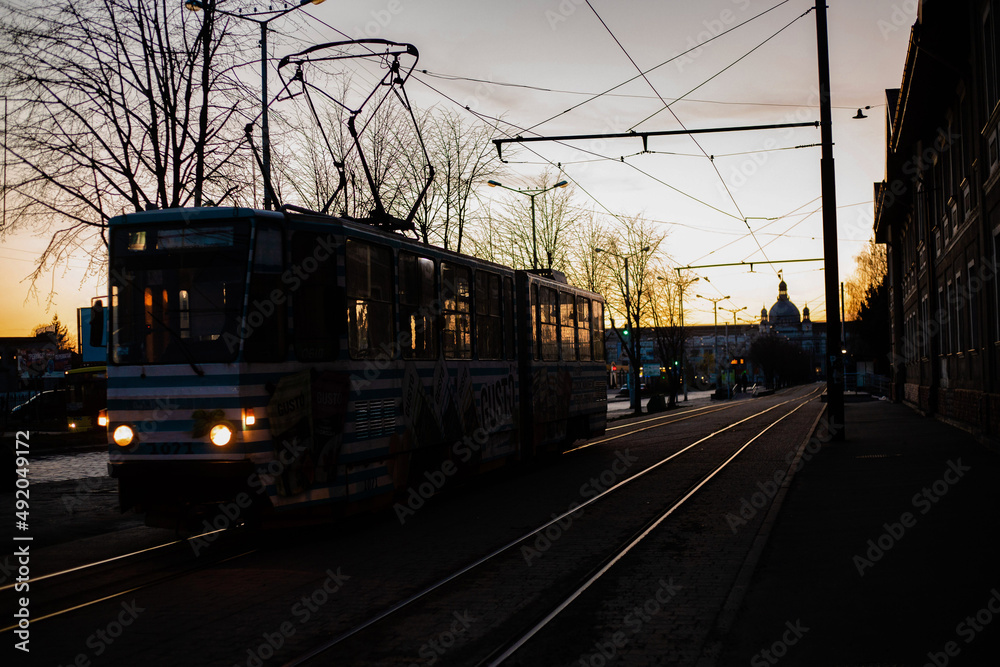Silhouette of tram leaving Lviv train station during the sunset