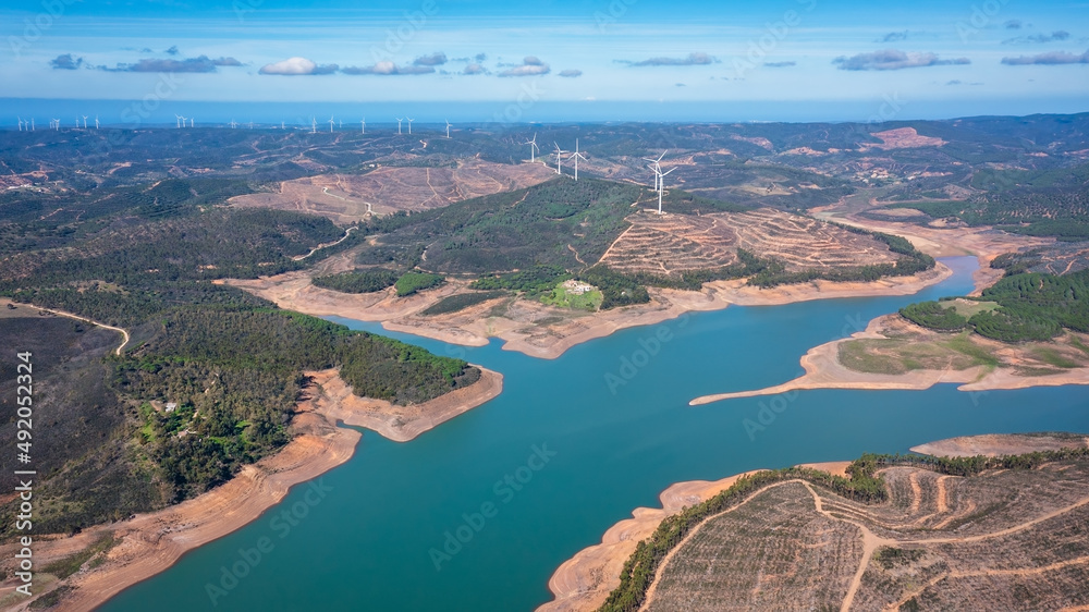 Aerial. Photo from sky, dams filled with water Bravura Portimao. in background, a park of wind generators for clean ecological electricity.
