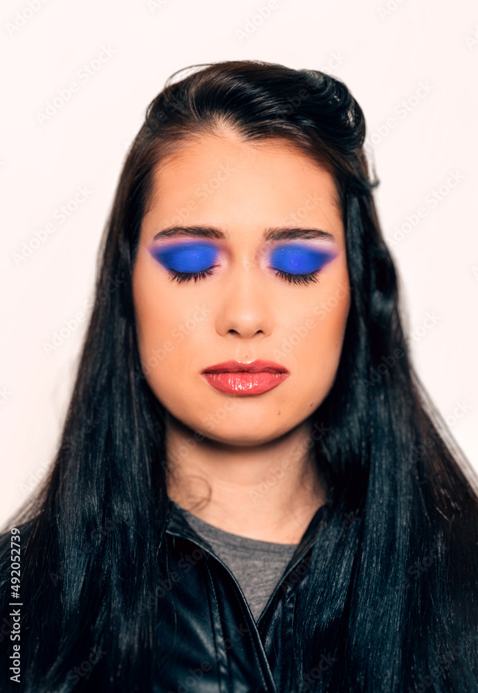 portrait of a woman with closed eyes and blue makeup and lipstick - attractive young woman with long black hair