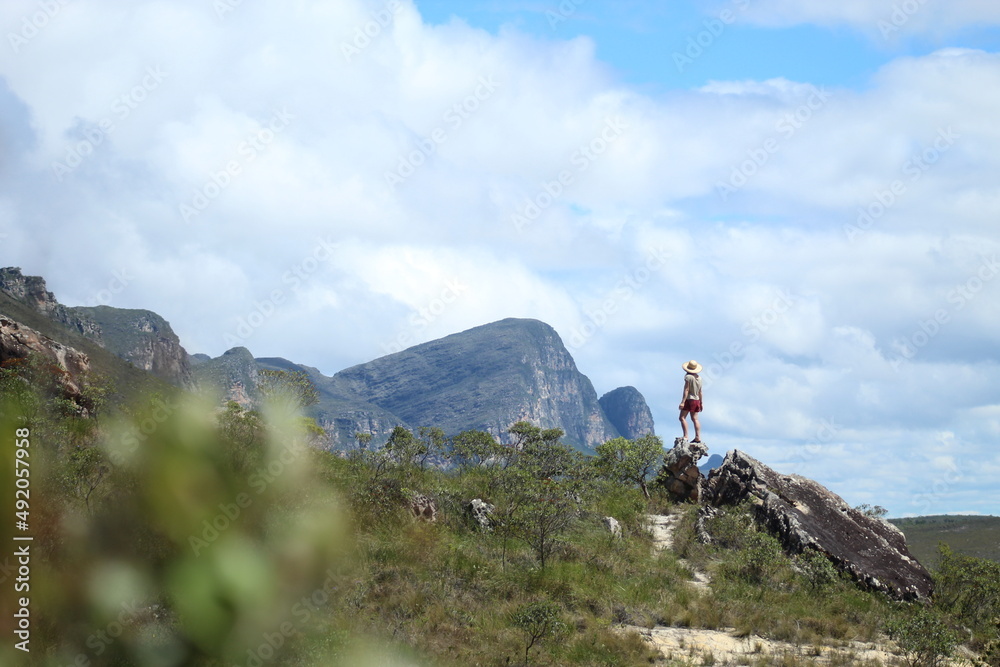 mulher caminhando com montanhas ao fundo na Chapada Diamantina