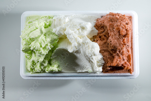 trittico di   vari gusti di gelato su vaschetta da asporto photo