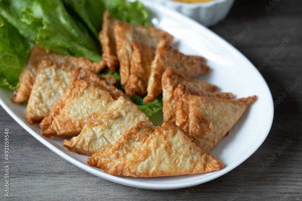 Triangular fried tofu eating with spicy dipping sauce, sweet and spicy Triangular fried tofu eating with spicy dipping sauce, sweet and spicy