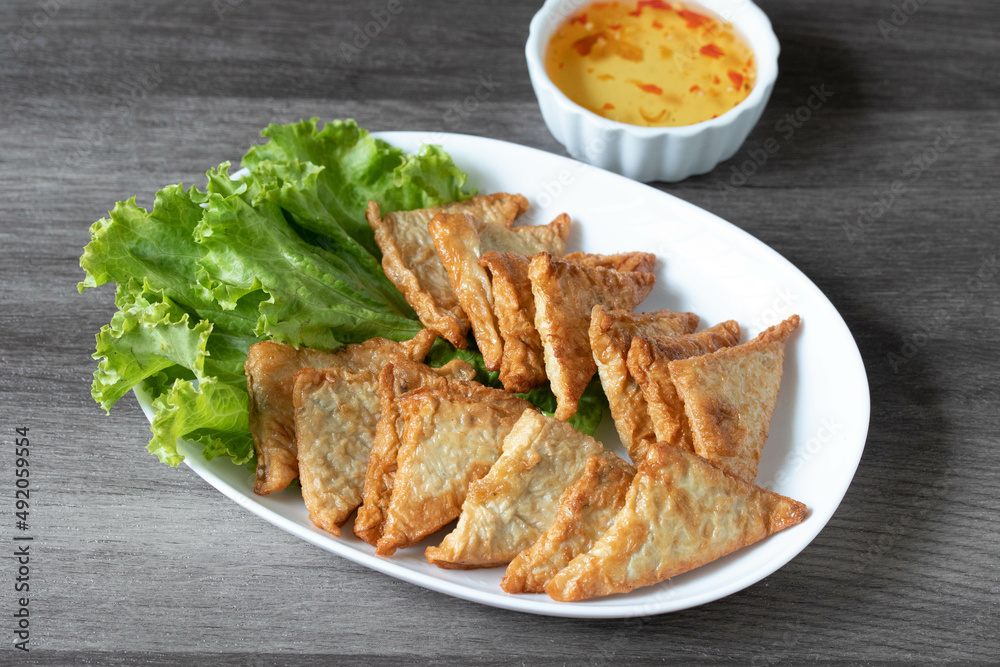 Triangular fried tofu eating with spicy dipping sauce, sweet and spicy