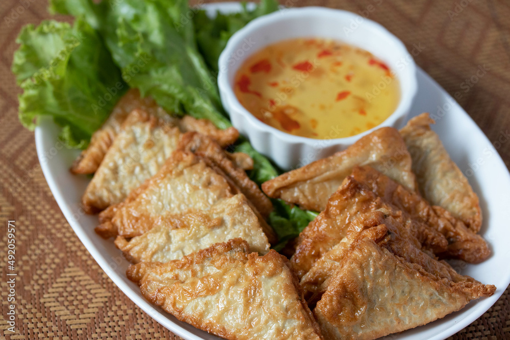 Triangular fried tofu eating with spicy dipping sauce, sweet and spicy Triangular fried tofu eating with spicy dipping sauce, sweet and spicy