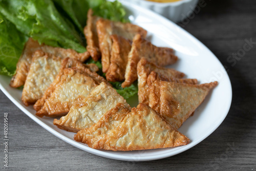 Triangular fried tofu eating with spicy dipping sauce, sweet and spicy