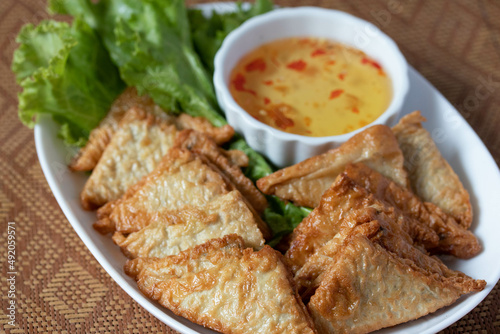 Triangular fried tofu eating with spicy dipping sauce, sweet and spicy